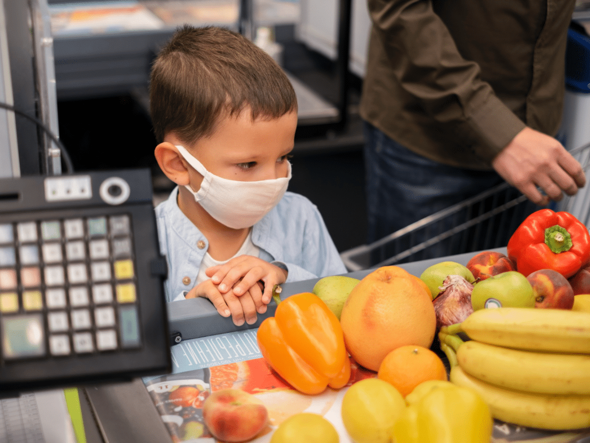 A parent and child shopping for fruits through the WIC program