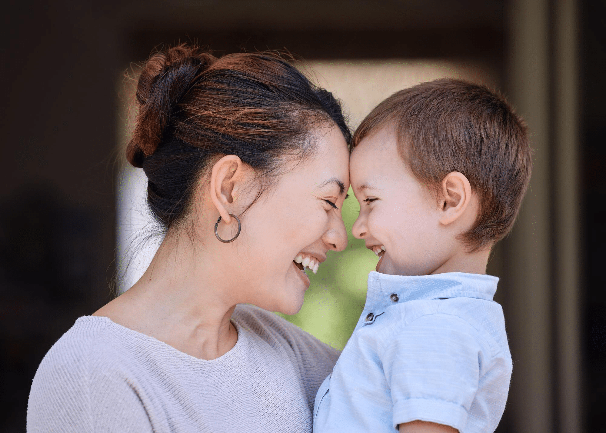 A child smiling and laughing with their mother after recovering from an RSV infection.