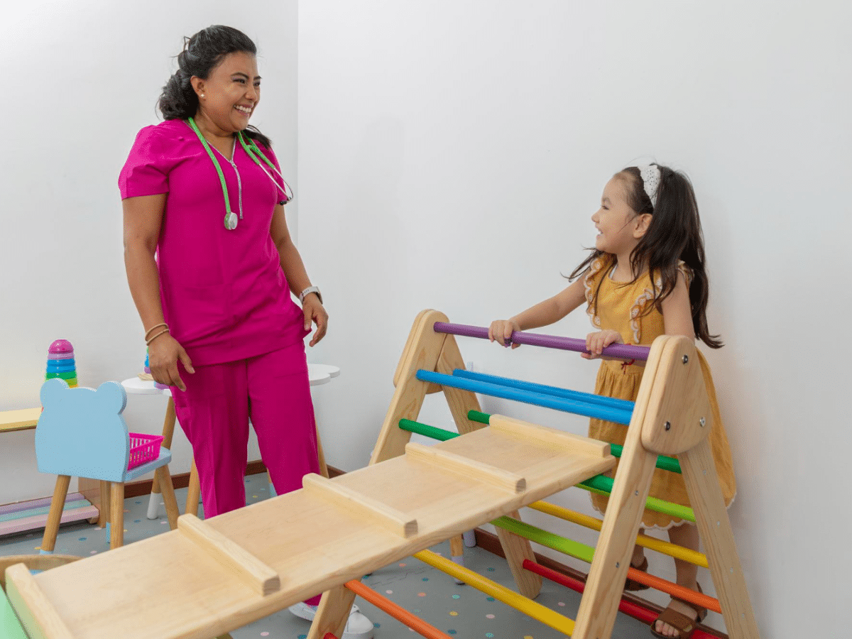 A friendly doctor conducts a mobility check with a patient at the best pediatric clinic in Fresno.