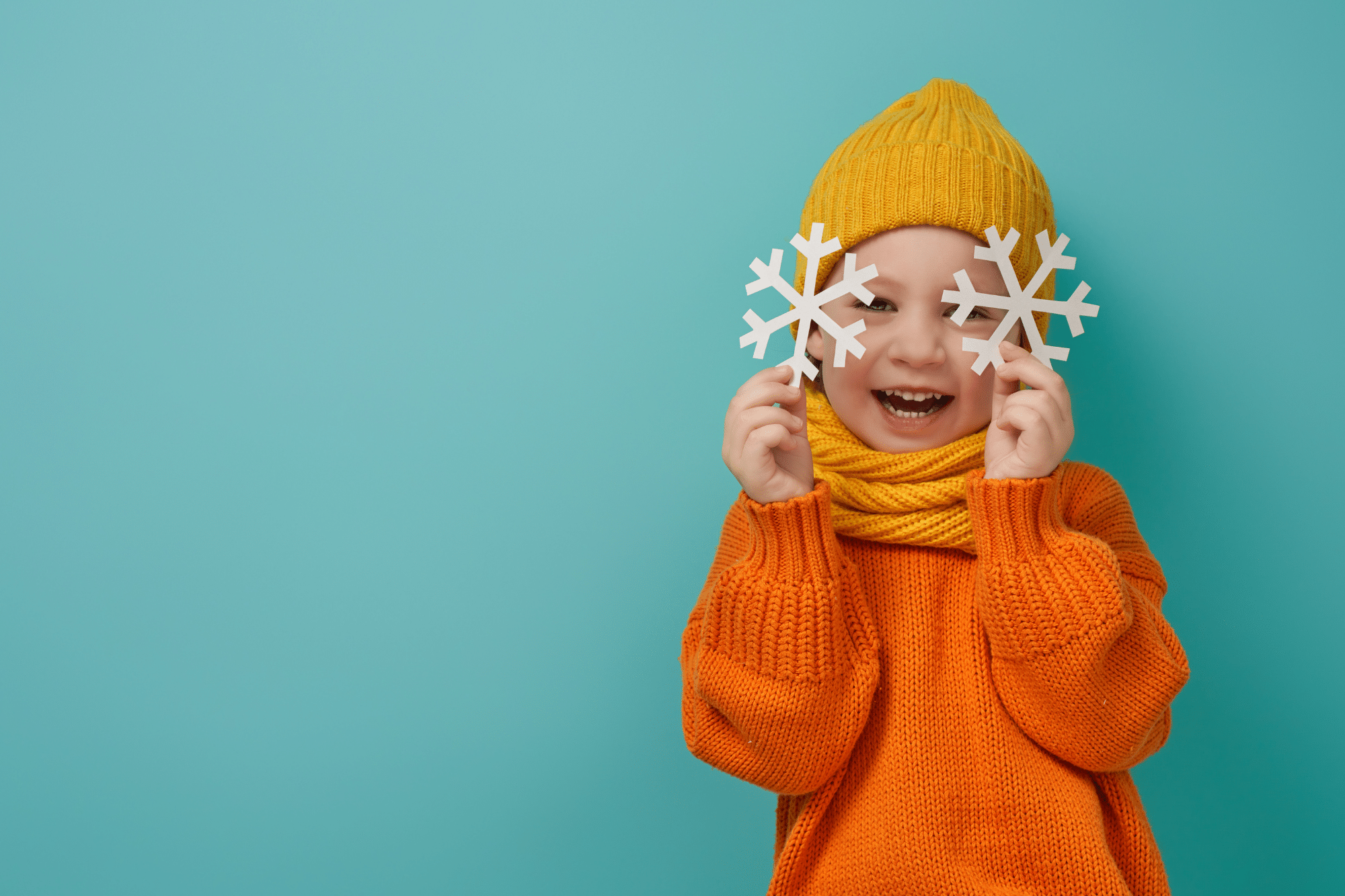 A little boy happily plays with the snowflake-shaped paper after recovering from RSV cold.