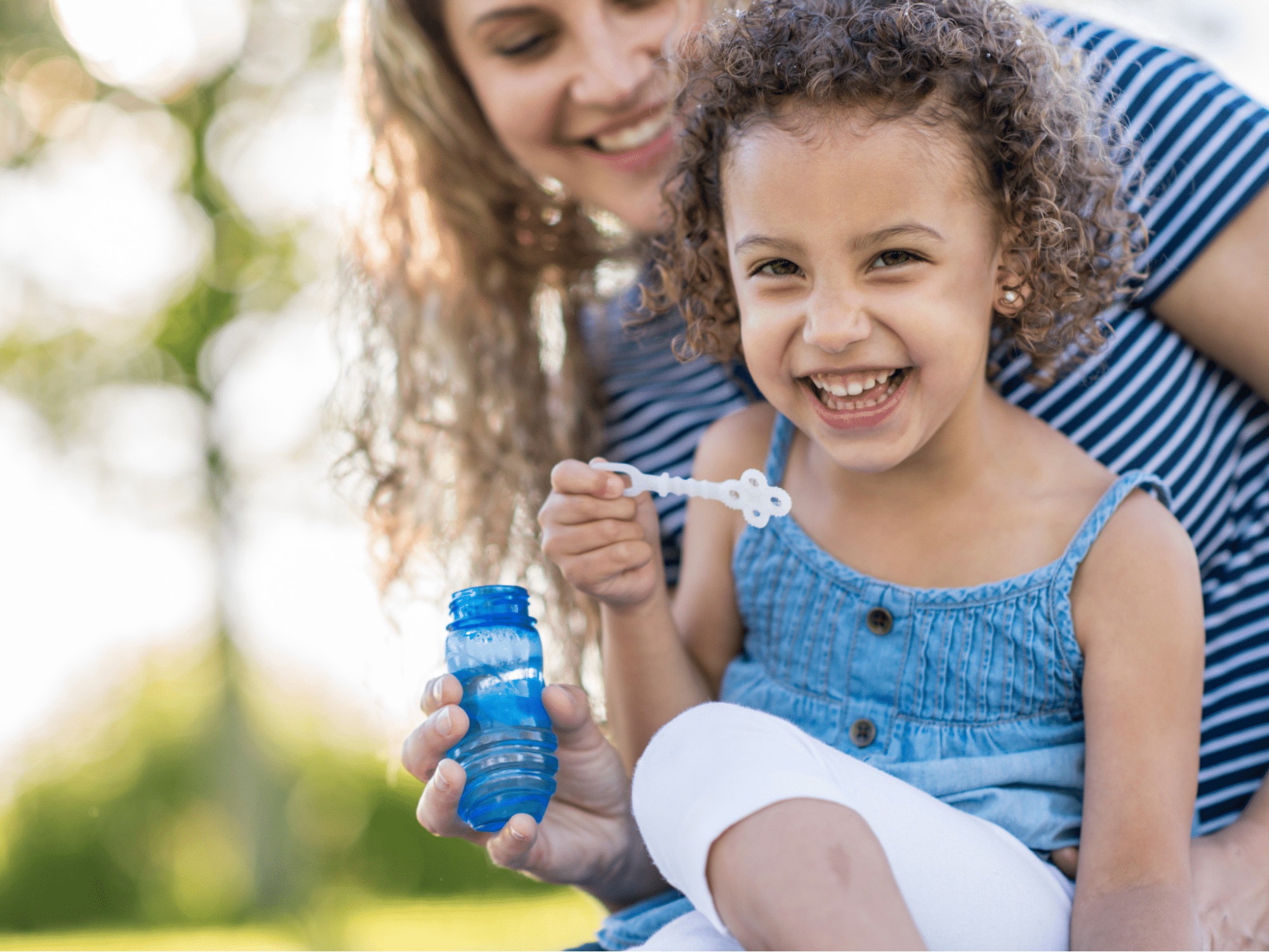 Diapered baby on soft bedding with medicated cream for skin rash treatment.